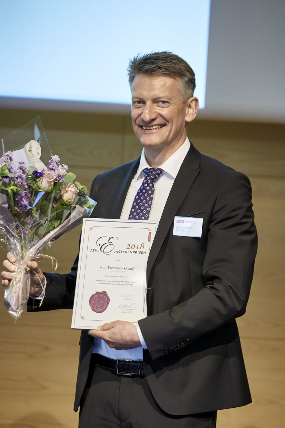 Photo of Professor Kurt Gothelf with the ATV prize from the Danish Polymer award ceremony.